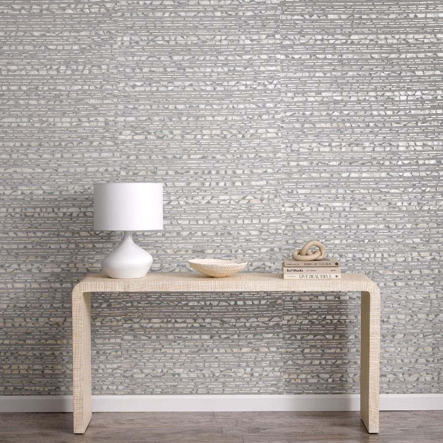 Capiz shells form the horizontal stripes of Shoreline, meticulously woven together by hand with a metallic warp yarn that enhances the natural pearlescent shine of the shells.  Whether in a coastal retreat or a city penthouse, this opulent wallcovering adds stunning layers to the wall.  The strips are cut into varying widths to unveil the metallic backing, further accentuating the natural texture of the shells.